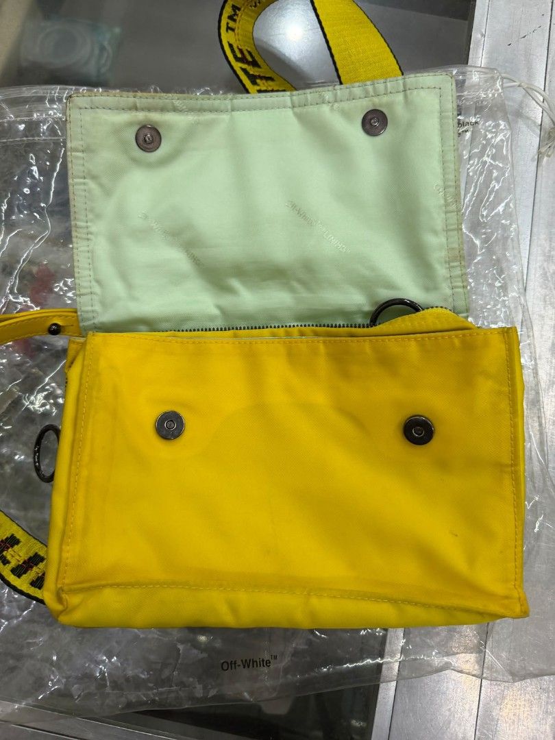 Off-White Yellow Crossbody Bag (Category: Cross-body Bags) located in Manila. Submitted by gmfhardware (Listing ID 1467839642, Image 2). Description: - Authentic Off-White crossbody bag in bright yellow - Contrasting light green interior lining with branded text pattern - Secure zip closure and snap button details - Includes functional inner zip pockets - Adjustable signature yellow industrial strap - Made in Italy tag intact - Clean canvas body,