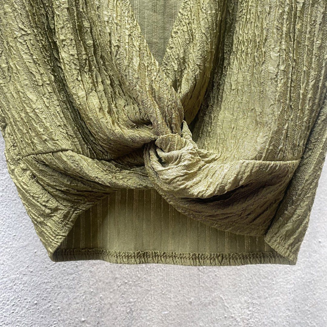 Olive green crinkle crop top with front twist (Category: Shirts) located in Muntinlupa City. Submitted by 4eva3volve (Listing ID 1467946636, Image 2). Description: - Color: Green - Style: Crop top with deep V-neckline, short sleeves, and front twist knot detail - Texture: Crinkled texture all over (front and back) - Fit & Fabric: Lightweight, stretchy, and comfortable - Condition: Like new, worn only once or twice - Care: Machine washable.
