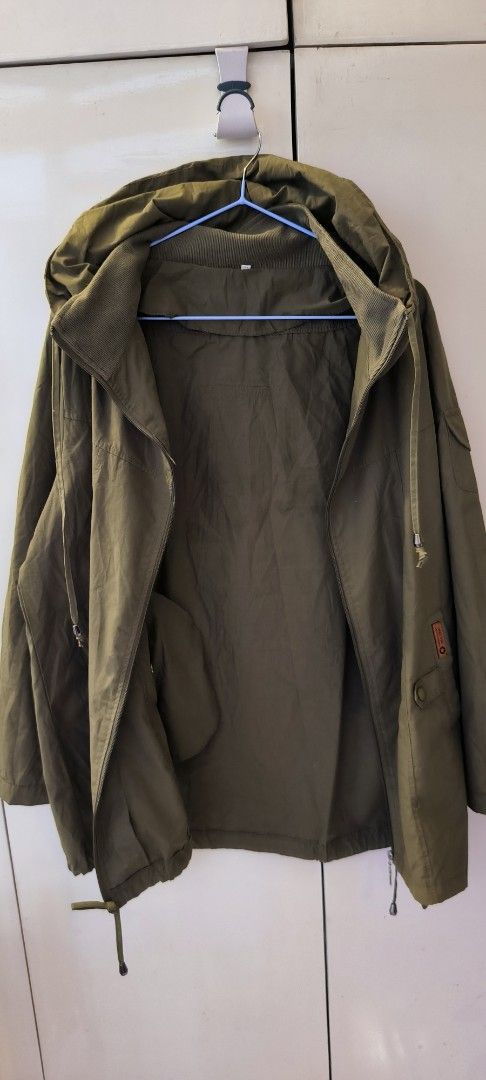 Olive green hooded jacket with front pockets and drawstrings (Category: Coats, Jackets and Outerwear) located in Paranaque City. Submitted by lizpretty05 (Listing ID 1467842135, Image 3). Description: - Color: Olive green - Closure: Full zip front - Pockets: Two lower snap-button pockets plus a left arm sleeve pocket - Comfort: Ribbed collar lining for extra warmth - Fit: Adjustable drawstrings at the hood and bottom hem - Style: Casual utility l