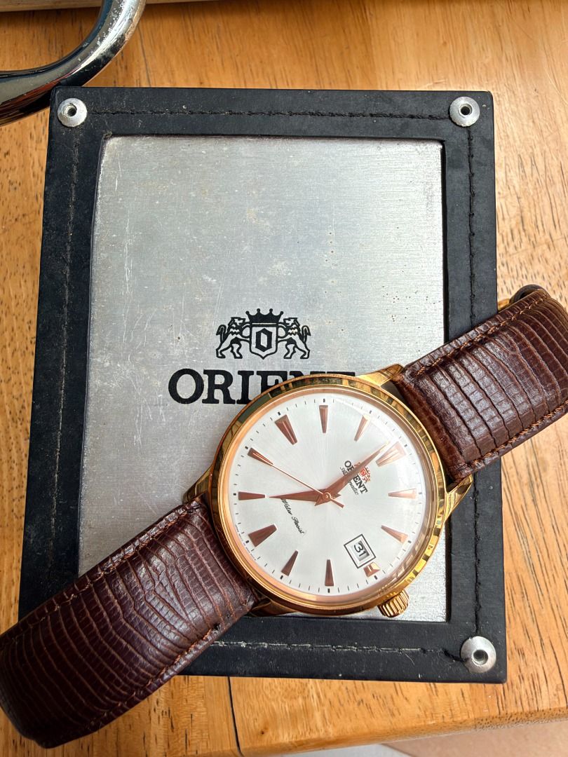 Orient Bambino Automatic Watch Rose Gold White Dial Leather Strap (Category: Men's Watches) located in Quezon City. Submitted by 30somethingtreasures (Listing ID 1467986491, Image 3). Description: - Brand: Orient Automatic Dress Watch - Dial: White dial with date window at 3 o'clock - Case: Rose gold tone case with stainless steel transparent exhibition back - Strap: Premium textured brown leather strap - Condition: Keeps excellent time - Inclusi