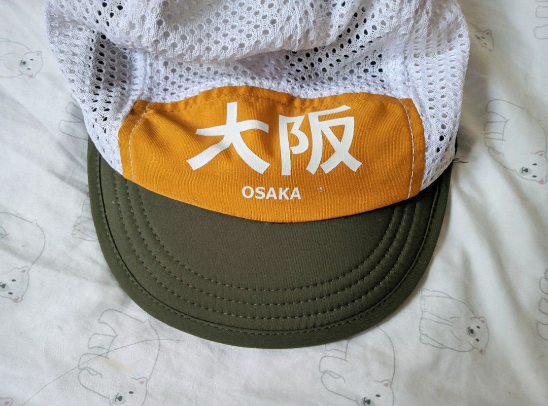 Osaka Cycling Cap White Green Mesh (Category: Caps & Hats) located in Butuan. Submitted by kkkai.zzzzz (Listing ID 1467849576, Image 2). Description: - White mesh cycling cap with green brim and yellow front panel - Features white Japanese kanji lettering reading "Osaka" - Lightweight and highly breathable for outdoor rides or runs - Brim can be adjusted up or down.