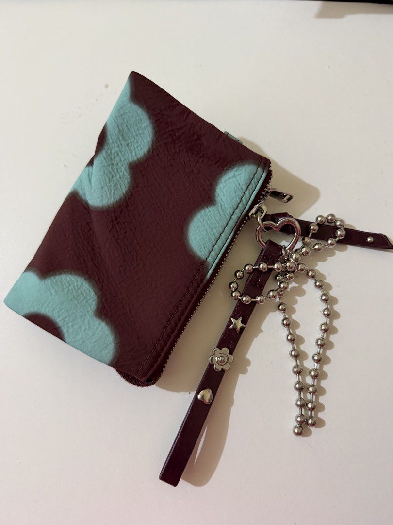 Parfois wallet (Category: Wallets & Card holders) located in Makati City. Submitted by beymadrigal (Listing ID 1467979950, Image 2). Description: Maroon wallet featuring a light blue flower pattern all over. Main zip closure with multiple interior compartments and a middle zippered pocket. Includes a detachable wristlet strap decorated with metal charms, star, flower, and heart studs, plus a silver ball chain attachment..