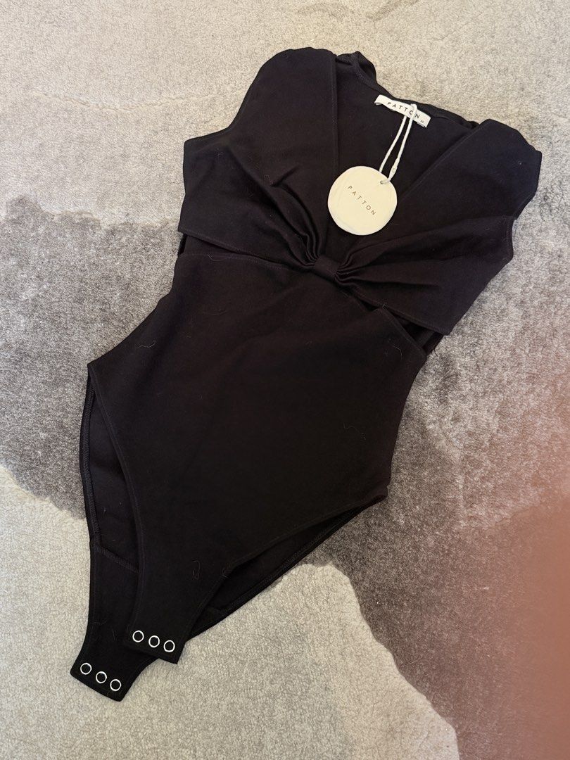 Patton Black Cutout Bodysuit (Category: Sleeveless) located in Pasig City. Submitted by milliedeluna (Listing ID 1467902589, Image 1). Description: - Condition: Brand new with tags (never worn) - Size: XS - Material/Finish: Black patent - Design: V-neck with front twisted knot detail and trendy side waist cutouts - Closure: Convenient snap buttons at the bottom.