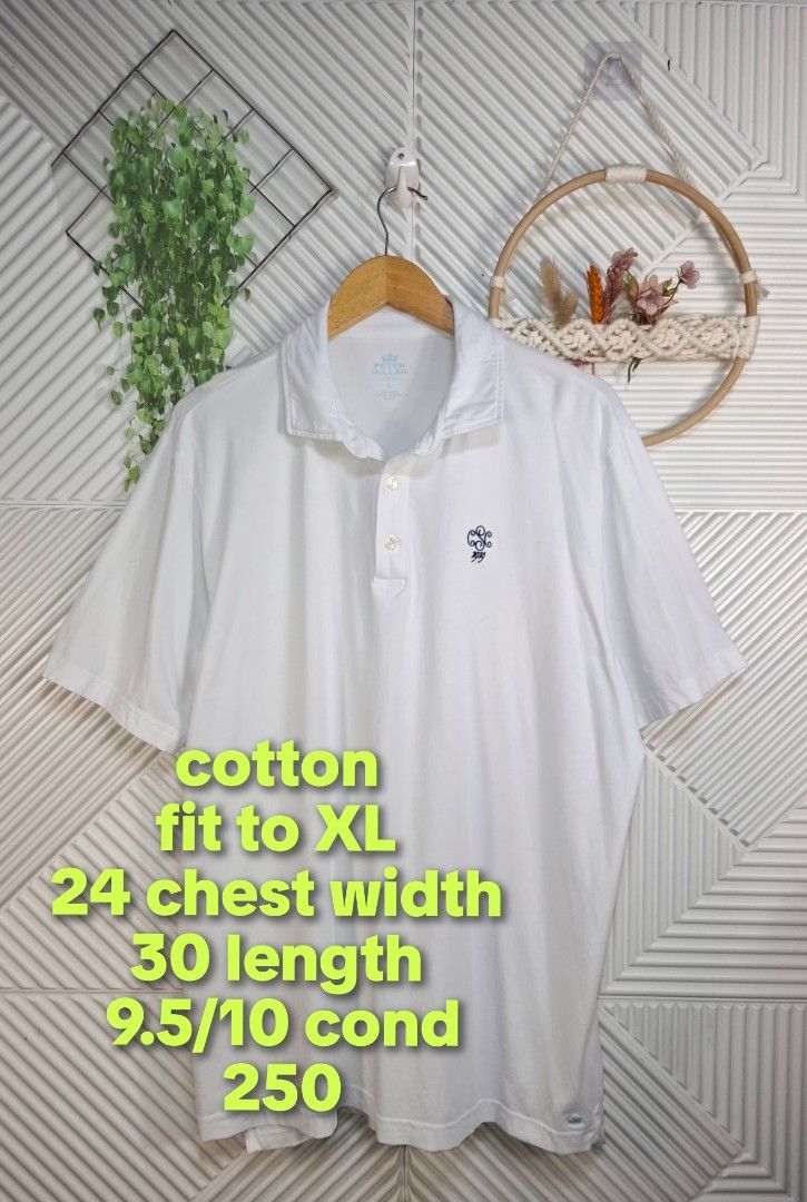 Peter Millar White Polo Shirt (Category: Tshirts & Polo Shirts ) located in Bulacan. Submitted by cathycampo51092 (Listing ID 1467841996, Image 3). Description: Peter Millar white polo shirt in size L, fits like an XL. Chest width measures 24 inches, length measures 30 inches. Made of 100% cotton. Features embroidered crest logo on the chest and small crown logo embroidery near the sleeve hem. Two-button placket closure at the neck. Condition rat