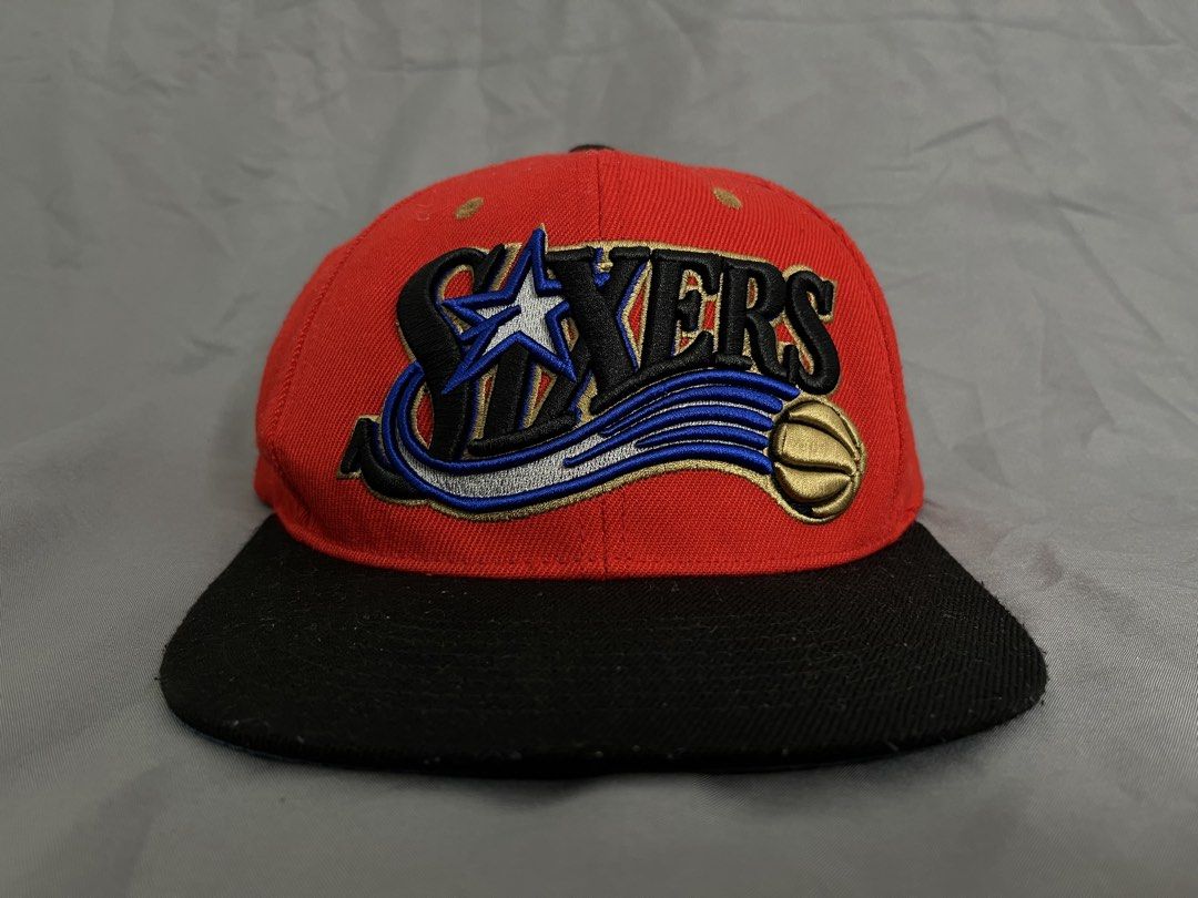 Philadelphia 76ers Mitchell & Ness Snapback Hat (Category: Caps & Hats) located in Imus. Submitted by graeyowl (Listing ID 1467974110, Image 1). Description: - Brand: Mitchell & Ness Hardwood Classics - Team: Philadelphia 76ers - Design: Red crown, black flat brim, and blue underbrim - Details: Raised embroidered team logo on front and script embroidery above the snap closure - Authenticity: Includes Spalding NBA hologram sticker on the underbrim