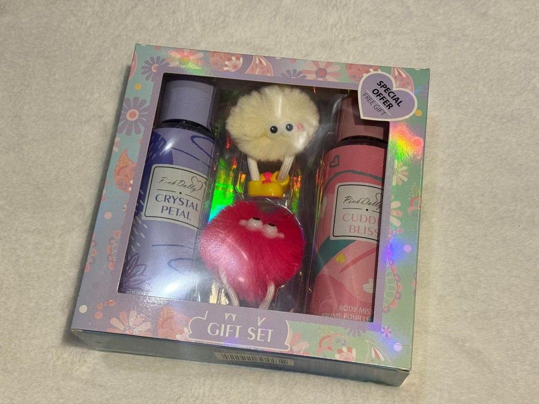 Pink Dolly Crystal Petal & Cuddle Bliss Gift Set (Category: Fragrance & Deodorants) located in Quezon City. Submitted by trade_mnl (Listing ID 1468057515, Image 1). Description: - Brand new & unopened Pink Dolly gift set - 2x 250ml body mists: Crystal Petal and Cuddle Bliss - 2x cute plush keychains with googly eyes (white and pink) - Stunning holographic packaging with floral patterns - Perfect and ready-to-give present for fragrance lovers.