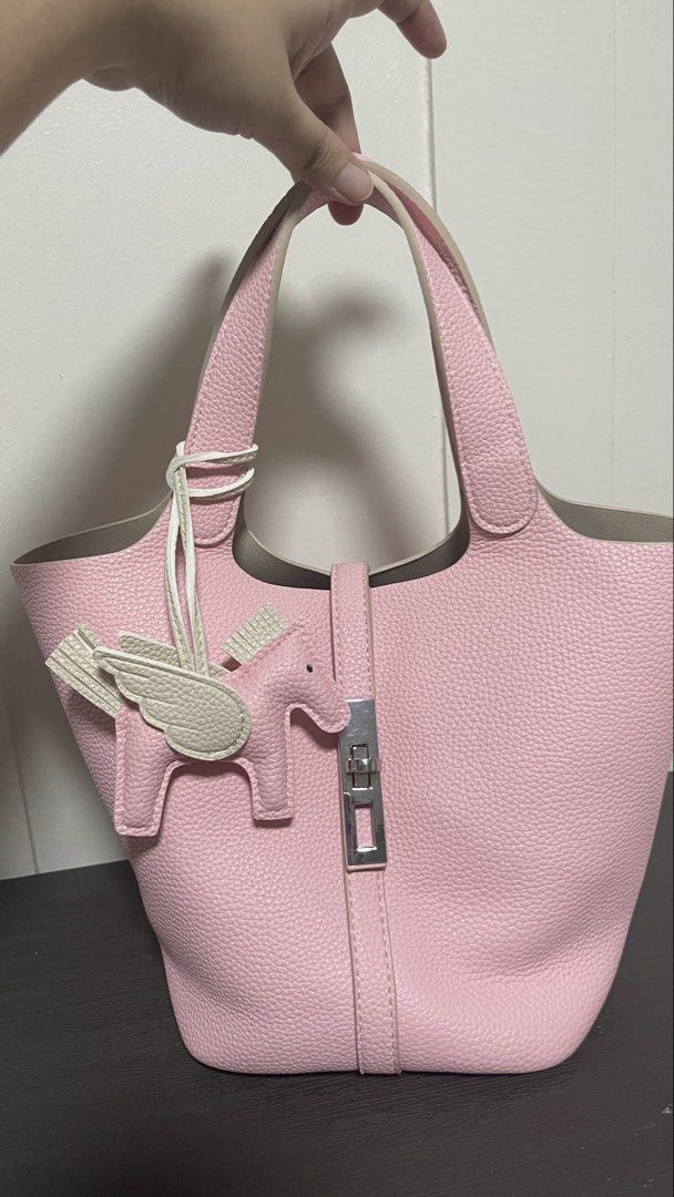 Pink Tote Bag with Pegasus Charm (Category: Tote Bags) located in Magalang. Submitted by josephinenl (Listing ID 1467898404, Image 1). Description: - Stylish textured pink bucket tote with sturdy handles - Elegant silver-tone lock hardware closure - Comes with a matching pegasus-shaped bag charm with white wings - Includes a zippered interior organizer pouch in grey herringbone fabric with pink trim - Perfect everyday bag for work, casual outings