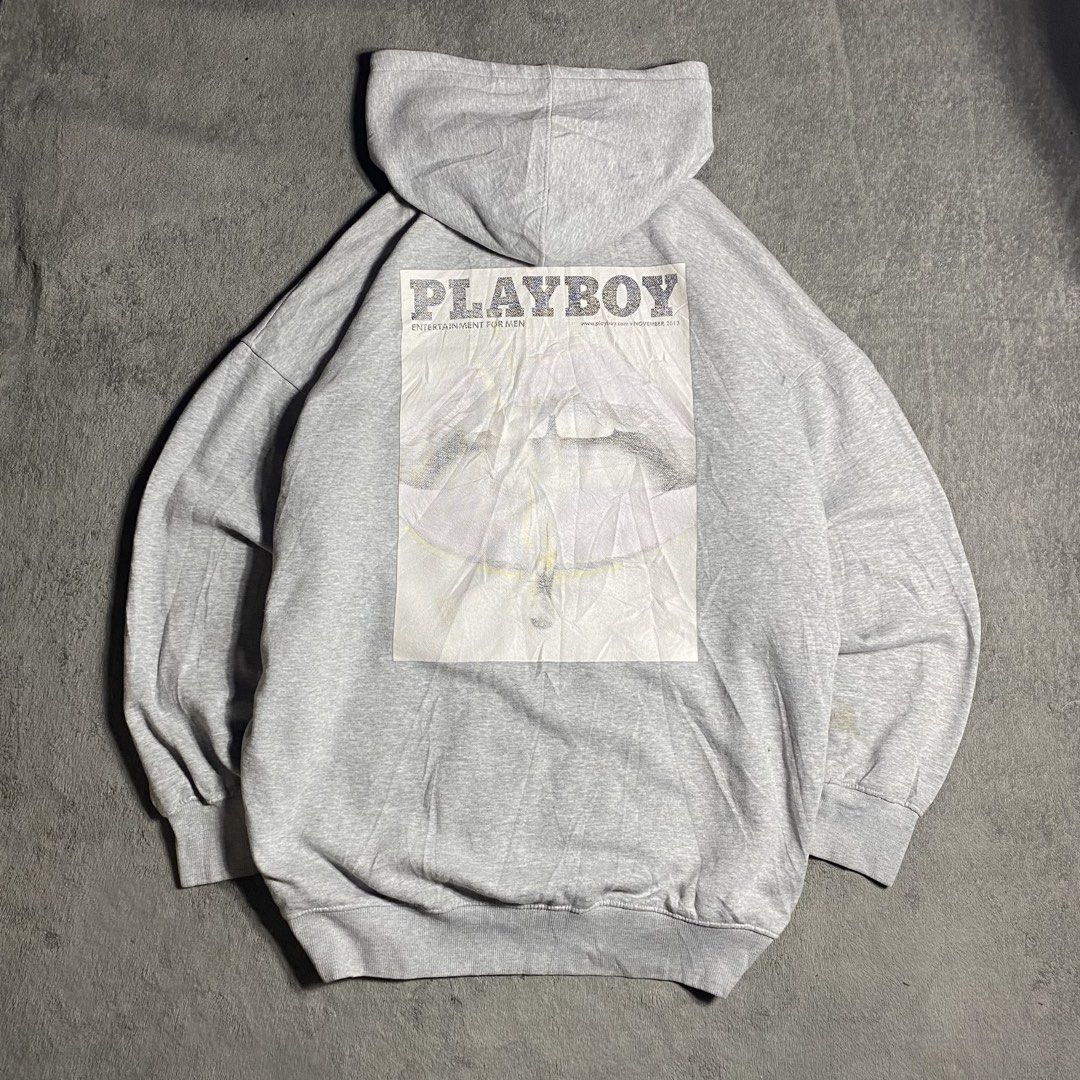 Playboy Grey Graphic Hoodie (Category: Coats, Jackets and Outerwear) located in Manila. Submitted by thrifturfit_star (Listing ID 1467845279, Image 2). Description: - Style: Grey Playboy hoodie with a relaxed, oversized fit - Back Design: Large, eye-catching magazine cover print - Front Detail: Purple embroidered Playboy logo on the chest - Features: Adjustable drawstring hood, front kangaroo pocket, ribbed cuffs and hem - Condition: Shows some s