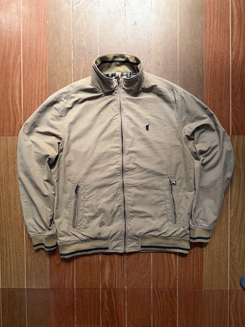 Polo Ralph Lauren Beige Bomber Jacket (Category: Coats, Jackets and Outerwear) located in Dasmarinas. Submitted by kylebecker (Listing ID 1467943964, Image 1). Description: - Brand: Polo Ralph Lauren - Color: Classic Beige - Style: Zip-up bomber jacket - Details: Signature embroidered pony logo on chest - Pockets: Two secure front zippered pockets - Trim: Ribbed collar, cuffs, and hem with dark blue stripes - Lining: Stylish plaid lining inside t