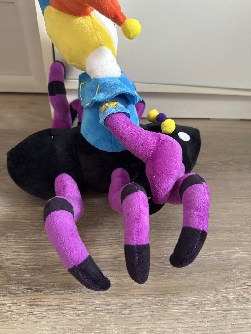 Poppy playtime (Category: Plushies & Soft Toys) located in Cainta. Submitted by shopbyyna (Listing ID 1467887147, Image 2). Description: - Unique jester and spider hybrid plush toy - Colorful blue, yellow, and orange jester hat with pom-poms - White skull head with blue collar and printed facial features - Black spider body featuring purple and black striped legs - Detailed with white embroidered eyes - Made with soft fabric throughout - Clean co
