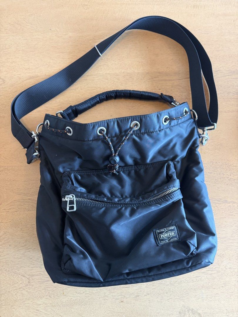 Porter Tokyo Japan Black Nylon Drawstring Shoulder Bag (Category: Sling Bags) located in Cebu City. Submitted by miguelgsarmiento (Listing ID 1467991270, Image 2). Description: - Authentic Porter Tokyo Japan shoulder bag in durable black nylon - Secure drawstring closure with an orange-flecked cord and toggle - Front zipped pocket featuring the classic Yoshida & Company woven label - Detachable black shoulder strap with sturdy silver-toned hardwa