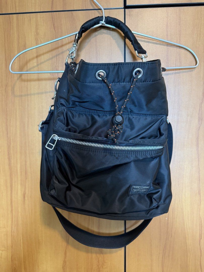 Porter Tokyo Japan Black Nylon Drawstring Shoulder Bag (Category: Sling Bags) located in Cebu City. Submitted by miguelgsarmiento (Listing ID 1467991270, Image 1). Description: - Authentic Porter Tokyo Japan shoulder bag in durable black nylon - Secure drawstring closure with an orange-flecked cord and toggle - Front zipped pocket featuring the classic Yoshida & Company woven label - Detachable black shoulder strap with sturdy silver-toned hardwa