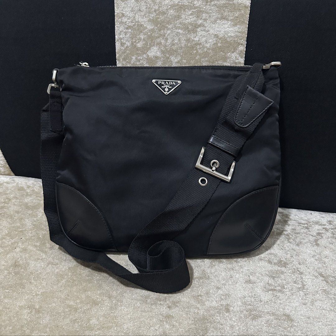Prada Black Nylon Crossbody Bag (Category: Luxury Bags & Wallets) located in Quezon City. Submitted by retroboominwantsummoh (Listing ID 1467335168, Image 1). Description: - Authentic Prada crossbody bag - Durable black nylon material with leather corner reinforcements - Classic silver-tone metal hardware - Iconic triangular Prada metal logo plaque on the front - Secure zip top closure - Adjustable black fabric shoulder strap - Clean interior and