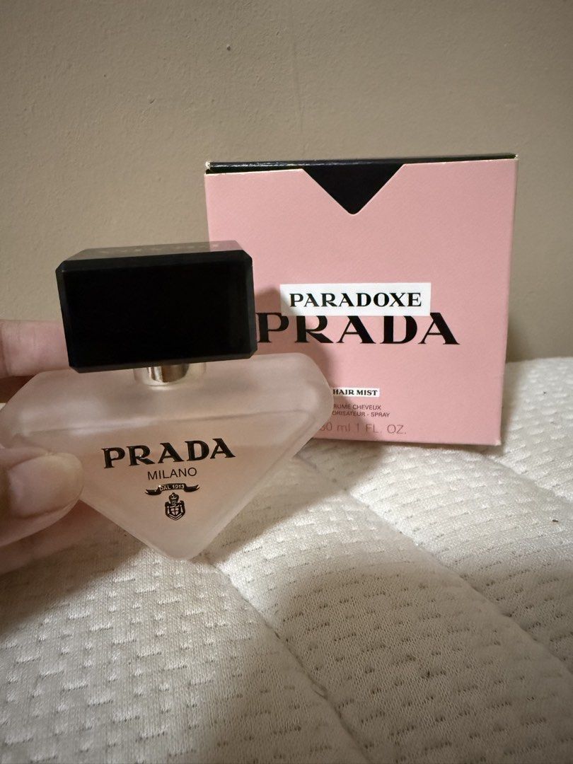 Prada Paradoxe Hair Mist 30ml (Category: Hair) located in Quezon City. Submitted by keyavien (Listing ID 1467972566, Image 2). Description: Kunin niyo na to hahahaha - Item: Prada Paradoxe Hair Mist - Size: 30ml in frosted triangle bottle with black and gold cap - Condition: Like new, sprayed few times ti test - Scent: Floral - Packaging: Includes original pink box (has minor handling marks from storage) .
