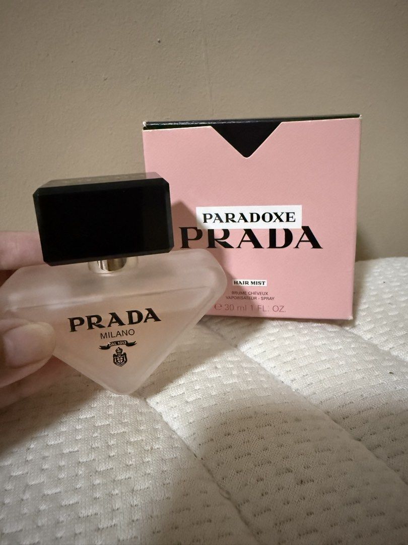 Prada Paradoxe Hair Mist 30ml (Category: Hair) located in Quezon City. Submitted by keyavien (Listing ID 1467972566, Image 3). Description: Kunin niyo na to hahahaha - Item: Prada Paradoxe Hair Mist - Size: 30ml in frosted triangle bottle with black and gold cap - Condition: Like new, sprayed few times ti test - Scent: Floral - Packaging: Includes original pink box (has minor handling marks from storage) .