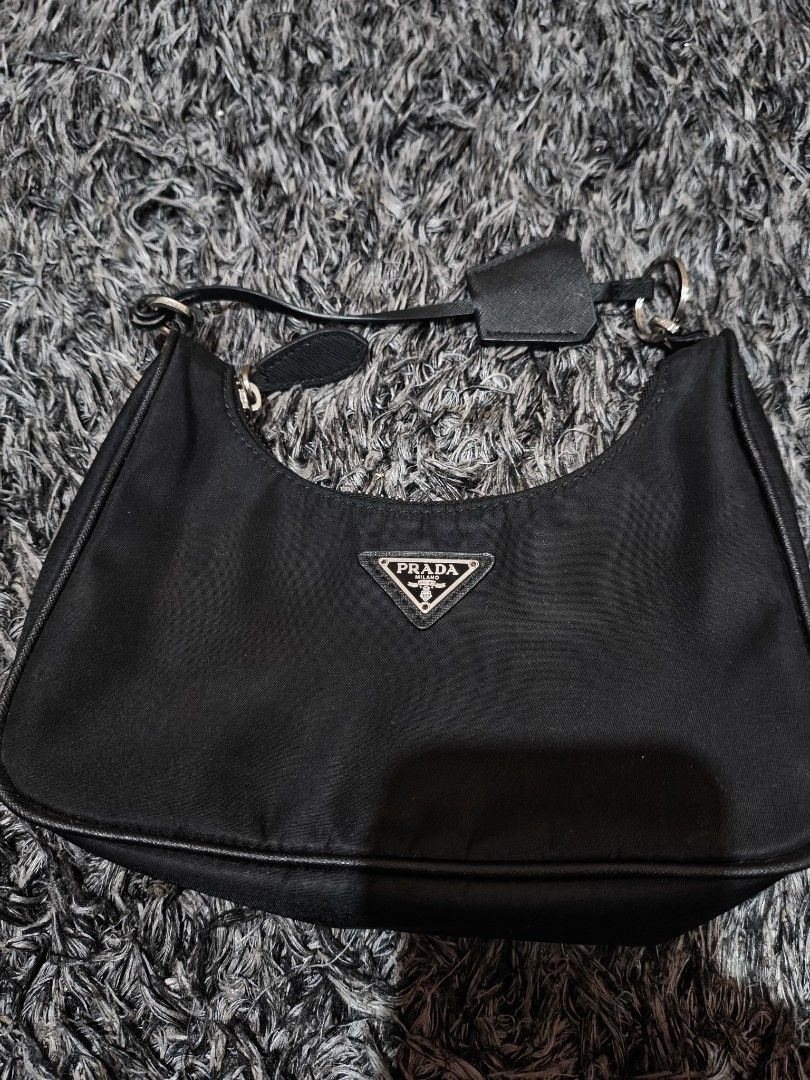 Prada Re-Edition 2005 Nylon Black Shoulder Bag (Category: Luxury Bags & Wallets) located in Laguindingan. Submitted by jingsuu22 (Listing ID 1467864446, Image 1). Description: - Brand: Prada Re-Edition 2005 - Color: Classic Black - Material: Durable signature nylon with silver-tone hardware - Features: Iconic metal triangle logo on front and matching detachable zipped pouch on the strap - Interior: Prada logo fabric lining with metal plaque label