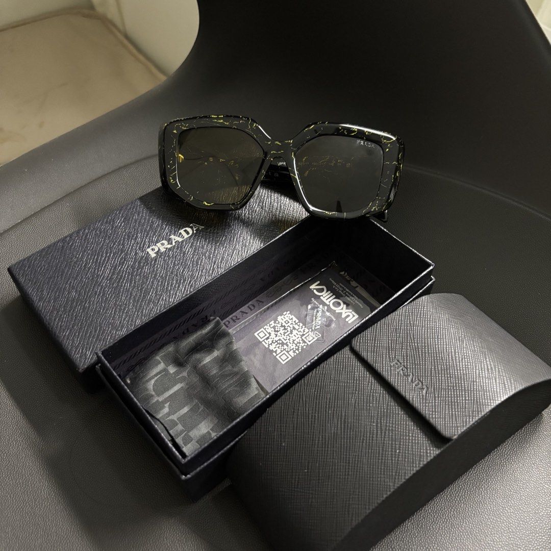 Prada Symbole (Category: Sunglasses & Eyewear) located in Makati City. Submitted by dianedelro (Listing ID 1467936332, Image 1). Description: - Brand: Prada - Model: Symbole Sunglasses - Colorway: Black with yellow marble/splatter pattern - Inclusions: Original Prada hard case, outer box, cleaning cloth, and documentation - Features iconic Prada triangular logo on the temples .