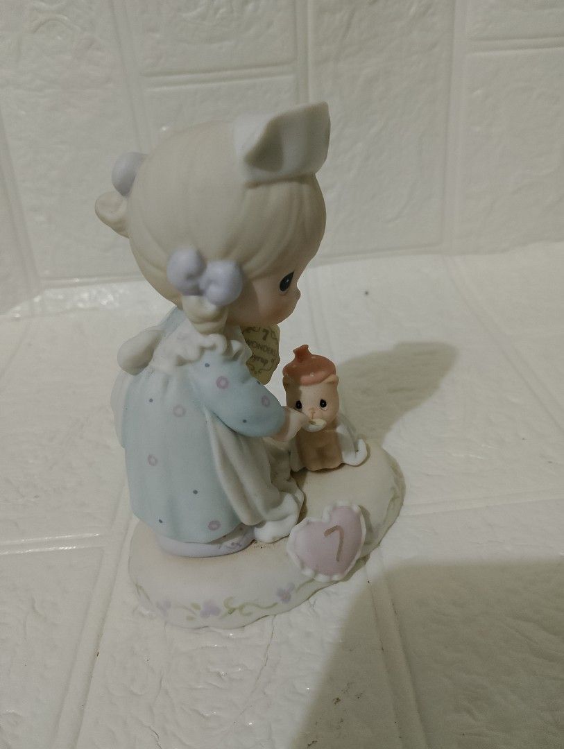 Precious Moments (Category: Figurines & Statues) located in Manila. Submitted by alygudio (Listing ID 1467849497, Image 2). Description: - Authentic Precious Moments nurse figurine - Features a nurse feeding a tiny wrapped bear with Wonders Syrup - Charming pastel blue and white dress with purple ribbons - Unique heart-shaped base marked with the number 7 - Perfect for collectors or as a thoughtful gift.
