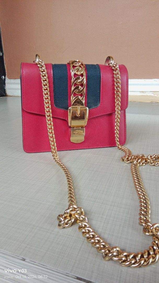 Preloved Gucci Shoulder Bag with Gold Chain (Category: Shoulder Bags) located in Cabuyao City. Submitted by selections888 (Listing ID 1467930441, Image 1). Description: - Color: Red with a contrasting front stripe and black piping - Hardware: Chunky gold chain strap and large gold front buckle - Shape: Structured box design with a clean mointerior space - Versatility: Can be worn as a shoulder bag or crossbody style - Condition: expect signs of u
