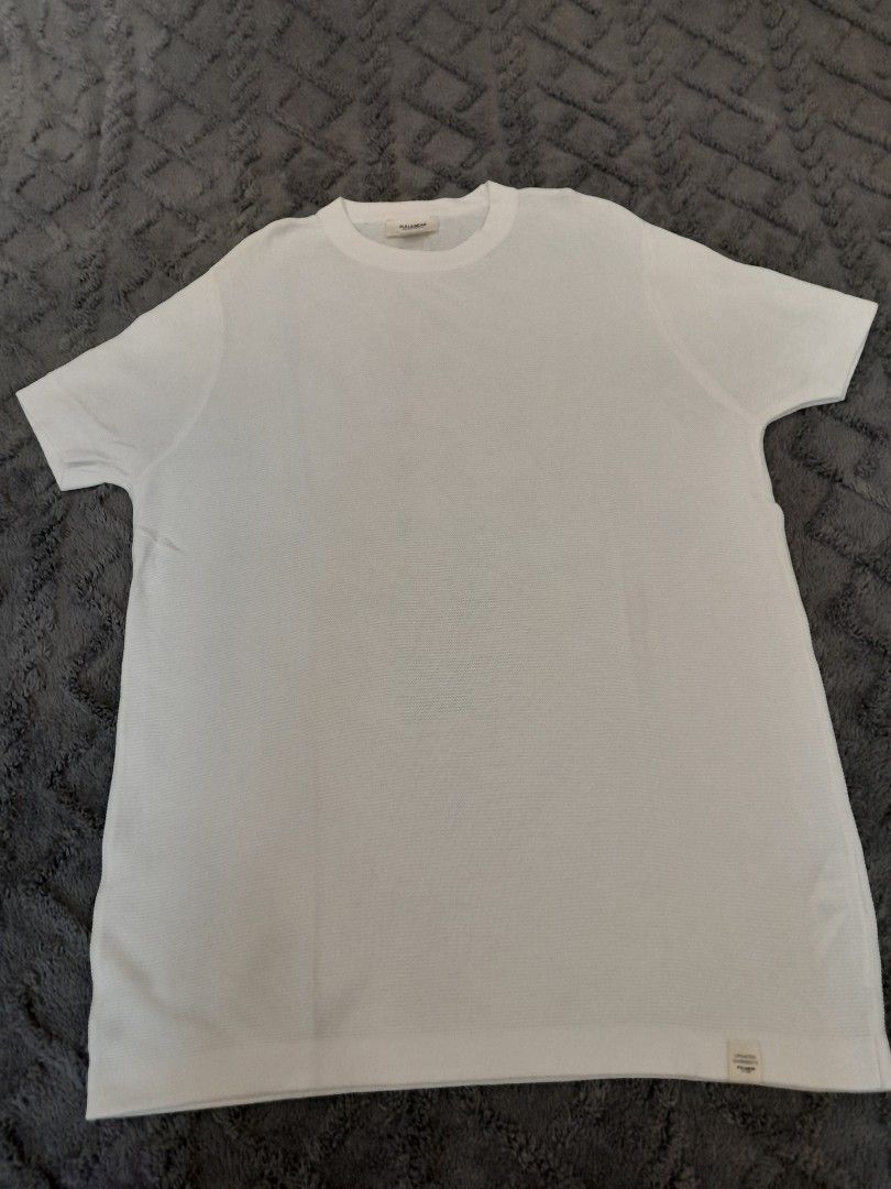 Pull&Bear White Waffle Knit T-Shirt (Category: Tshirts & Polo Shirts ) located in Las Pinas. Submitted by maljun1972 (Listing ID 1467926127, Image 1). Description: - Brand: Pull&Bear - Color: Clean White - Style: Short sleeves, classic crew neck - Material: Soft textured waffle knit fabric - Details: Small brand tag near the bottom hem - Measurements: Width ~21 inches, Length ~26 inches - Condition: Clean, excellent, and ready to wear.