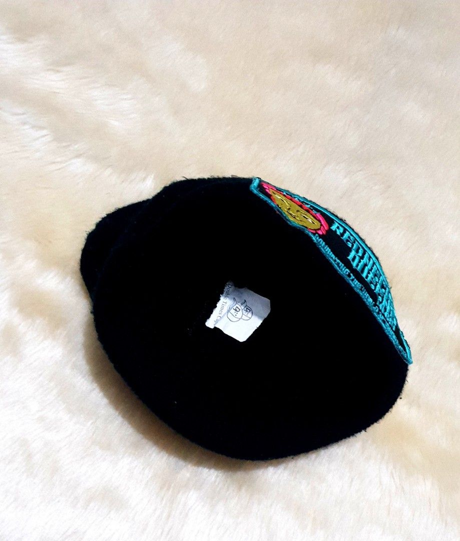 Red Necks & Queens Black Beanie Hat (Category: Caps & Hats) located in Taguig. Submitted by wethrifting2021 (Listing ID 1468014030, Image 2). Description: - Color: Black - Style: Knit beanie with folded brim - Details: Embroidered patch with cartoon face graphic, teal 'Red Necks & Queens MMXV' lettering, and 'Dominating The World Of Ignorance' tagline - Material: Thick, warm fabric ideal for cold weather - Condition: Excellent, interior tag intac