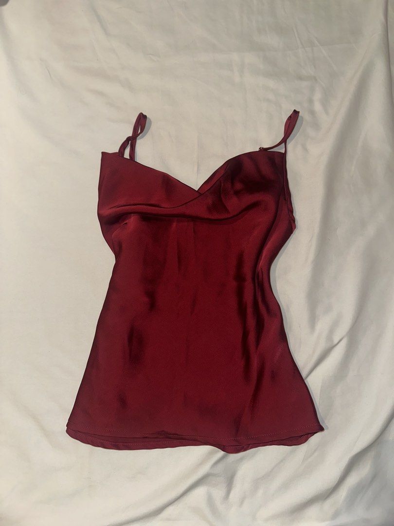 red satin cowl neck cami top (Category: Sleeveless) located in Quezon City. Submitted by kalmai (Listing ID 1467929301, Image 2). Description: - Color: Deep maroon - Material: Silky, high-quality satin with a beautiful front drape - Features: Cowl neckline, adjustable spaghetti straps, elegant gold hardware - Condition: Worn once for a quick photo, practically brand new - Styling: Pairs effortlessly with black pants or jeans for casual or night-o