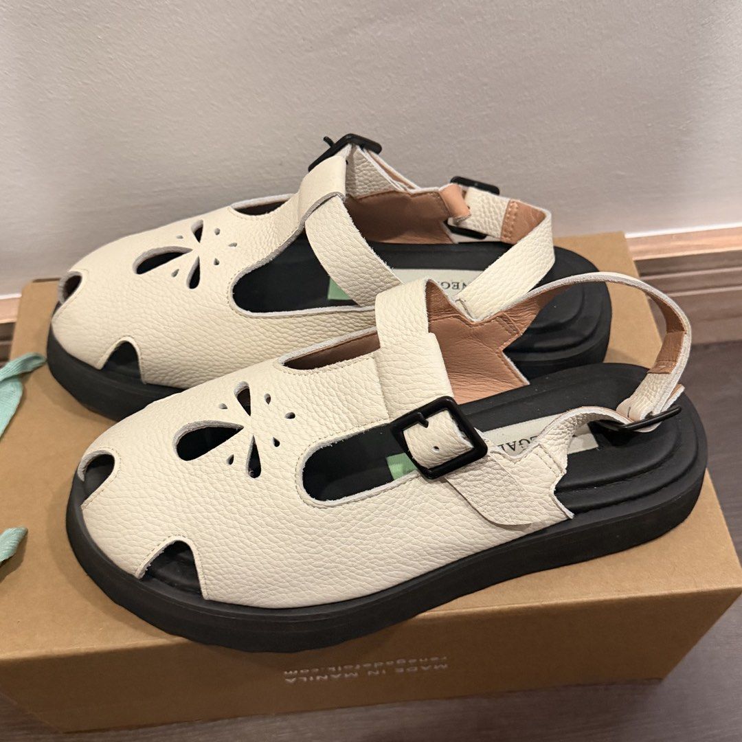 Renegade Folk White Leather Sandals (Category: Flats & Sandals) located in San Pedro. Submitted by love.bruce10 (Listing ID 1467898292, Image 2). Description: - Brand: Renegade Folk - Color: White with textured leather finish - Design: Closed-toe style featuring cute cutout flower patterns and adjustable buckle straps - Sole: Sturdy black lug soles with excellent tread grip - RFS too small - Inclusions: Comes with the original box - Condition: Ex