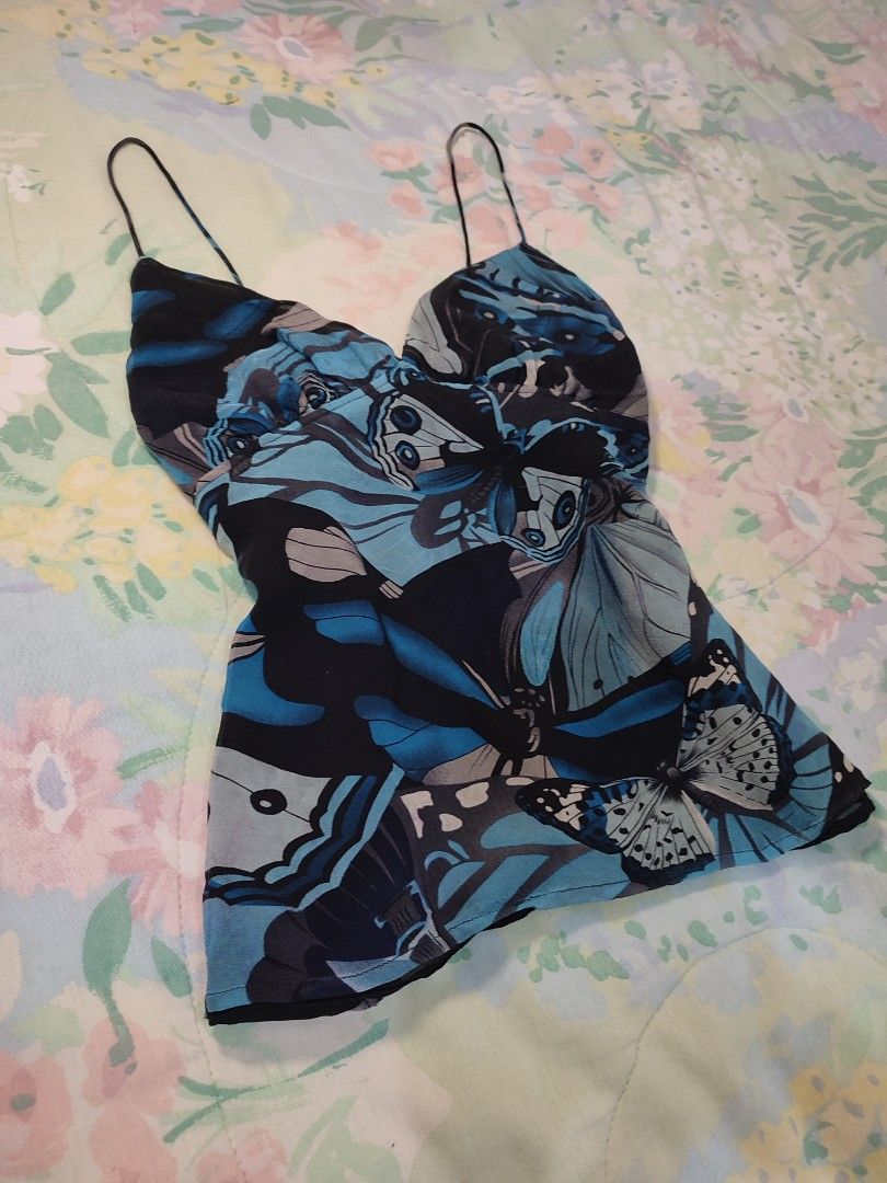 reworked Blue Butterfly Print Cami Top Spaghetti Strap (Category: Sleeveless) located in Jaen. Submitted by roxantiago (Listing ID 1468037254, Image 2). Description: - Color & Pattern: Blue and black with an all-over bold butterfly print - Design: V-neckline with delicate spaghetti straps - Fit: Adjustable tie detail at the back waist for a custom cinched look - Comfort: Fully lined interior made from lightweight, breezy fabric - Versatility: Ide