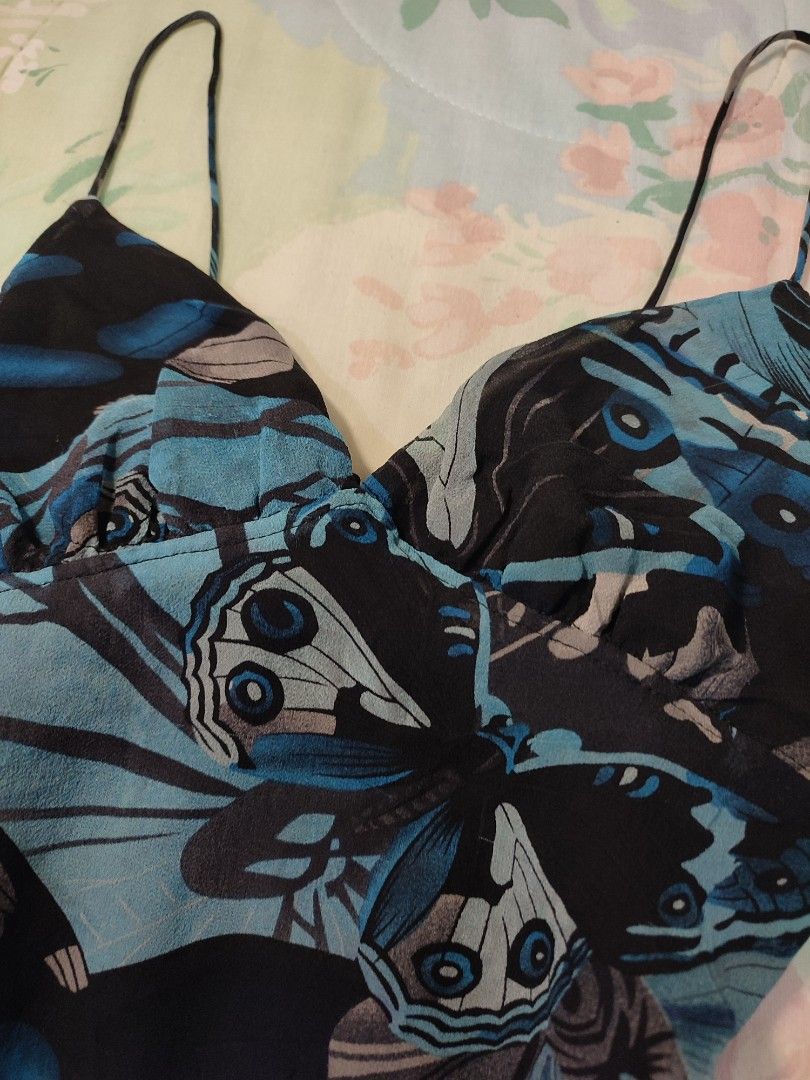 reworked Blue Butterfly Print Cami Top Spaghetti Strap (Category: Sleeveless) located in Jaen. Submitted by roxantiago (Listing ID 1468037254, Image 3). Description: - Color & Pattern: Blue and black with an all-over bold butterfly print - Design: V-neckline with delicate spaghetti straps - Fit: Adjustable tie detail at the back waist for a custom cinched look - Comfort: Fully lined interior made from lightweight, breezy fabric - Versatility: Ide