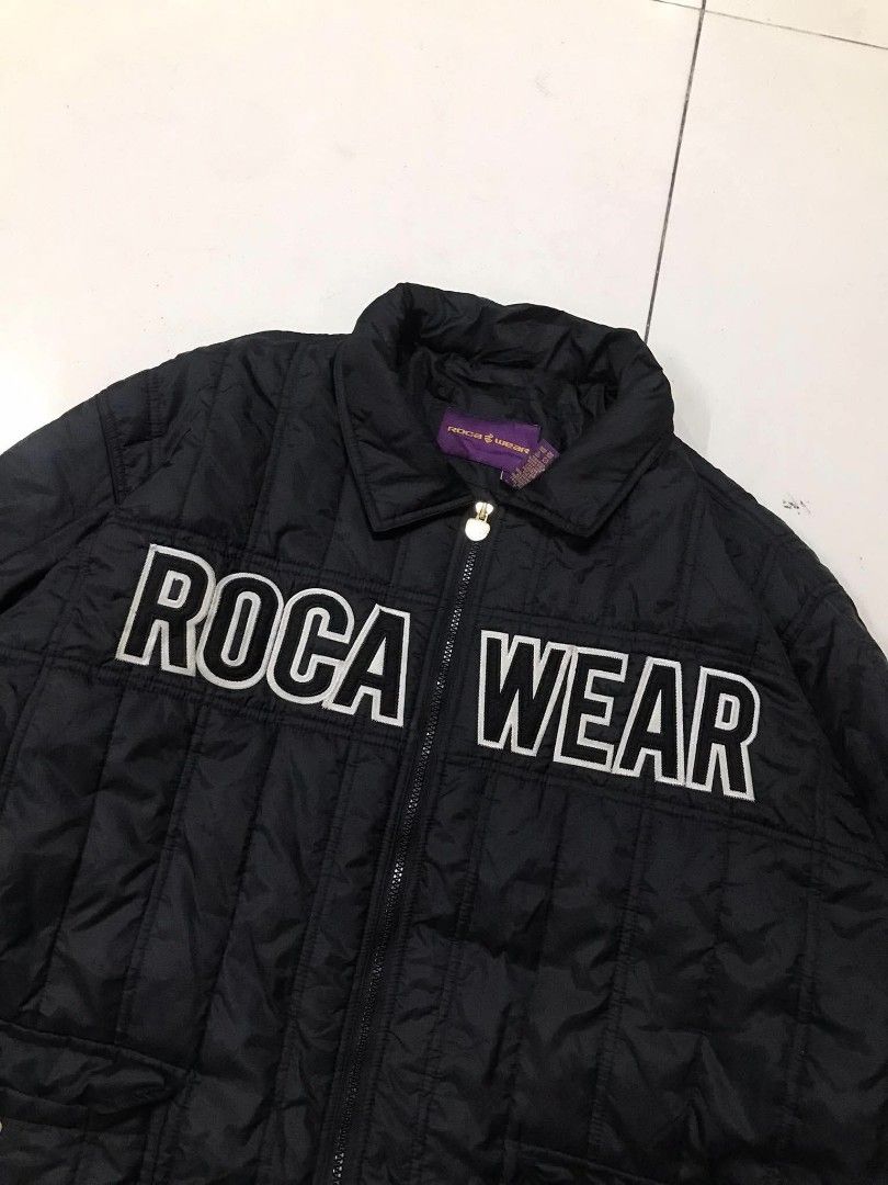Roca Wear Quilted Black Puffer Jacket 3XL (Category: Coats, Jackets and Outerwear) located in Manila. Submitted by youngstorm-c604 (Listing ID 1467895543, Image 3). Description: - Brand: Roca Wear - Style: Black quilted puffer jacket with relaxed oversized fit - Details: Bold white lettering across the chest - Closure: Zip-up front - Pockets: Functional pockets with snap buttons - Fit: Adjustable drawcord hem for a custom fit - Interior: Purple n