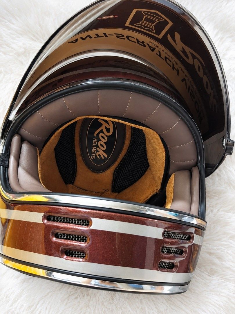 Rook Carter Motorcycle Helmet with Anti-Scratch Visor (Category: Bicycles) located in Mandaluyong City. Submitted by bisou_ph2 (Listing ID 1467931596, Image 3). Description: - Brand: Rook - Color: Brown metallic finish with chic chrome trim - Condition: Brand new, never worn, with original protective labels attached - Visor: Anti-scratch visor with protective film still on - Bonus: Includes an extra replacement visor in the package - Interior: Co