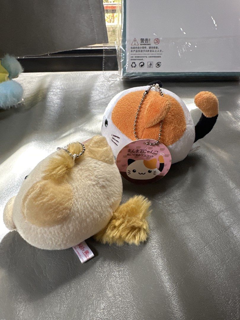Round1 & Calico Cat Plush Keychain Set (Category: Plushies & Soft Toys) located in Cainta. Submitted by shopbyyna (Listing ID 1467875828, Image 2). Description: - Set of 2 adorable cat plush keychains - Cat 1: Light yellow fuzzy cat with Round1 tag and pink paws - Cat 2: Round calico cat with orange, black, and white patches and original cardboard tag - Both feature attached ball chain keychains - Excellent, clean condition with tags intact.