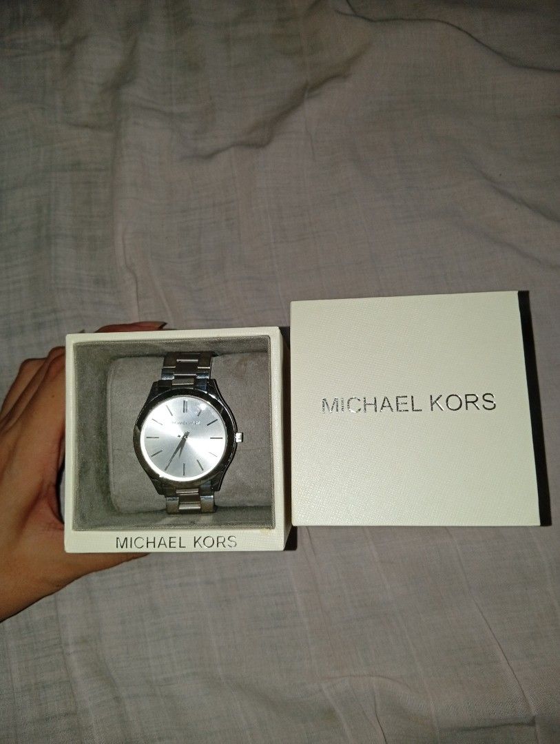 Rushed‼️ MK Slim Watch (Category: Women's Watches) located in Manila. Submitted by hermosa_la_tienda (Listing ID 1468051531, Image 1). Description: Michael Kors Slim Runway watch features a silver-tone stainless steel bracelet and a matching silver dial. The watch has a minimalist design with stick hour markers and the Michael Kors logo. The clasp is also branded with the Michael Kors name. RFS: need cash for maintenance pm for more details negot