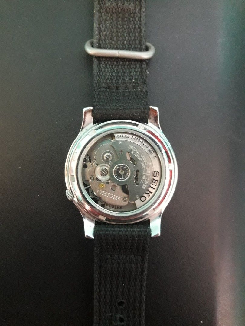 Seiko 5 Automatic Field Watch with Black Canvas Strap (Category: Men's Watches) located in Paranaque City. Submitted by omaraguirre (Listing ID 1467909500, Image 2). Description: - Model: Seiko 5 Automatic Watch - Dial: Classic green military-style with Arabic numerals - Movement: Reliable 21-jewel 7S26 automatic movement with transparent exhibition caseback - Strap: Durable black fabric NATO strap with sturdy metal hardware - Features: Convenien