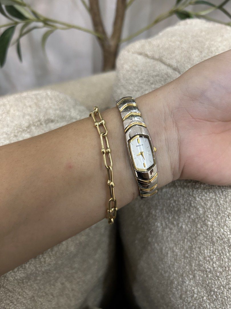 Seiko Two-Tone Bangle Watch (Category: Women's Watches) located in San Antonio. Submitted by katrizaclothing (Listing ID 1468058574, Image 1). Description: - Brand/Model: Seiko Vintage Bangle Watch - Colorway: Two-tone silver and gold - Dial: Rectangular white dial with gold hands and markers - Band: Comfortable textured link bracelet - Movement: Quartz (accurate timekeeping) - Style: Classic vintage, great for stacking with everyday jewelry.
