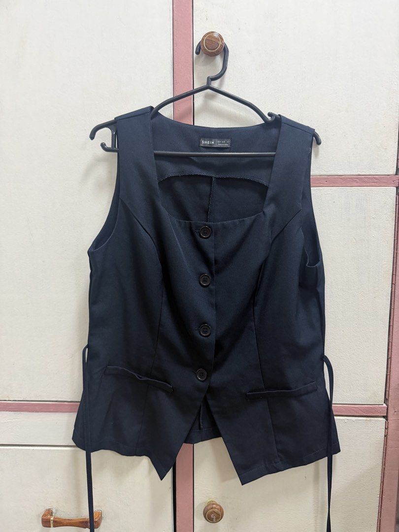 Shein Black Square Neck Button Vest Size M (Category: Sleeveless) located in Quezon City. Submitted by shop_mnl (Listing ID 1467976375, Image 3). Description: - Brand: Shein - Size: Medium (EU 38 / US 6) - Color: Black with slight textured fabric - Design: Square neckline, 4 front buttons, decorative hem pockets - Fit Feature: Back adjustable tie waist - Style Tip: Great versatile layering piece for office or casual wear.