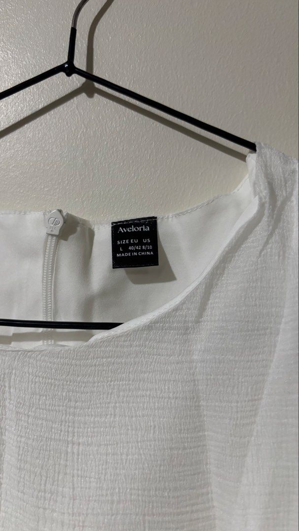 Shein Ruffled White Mini Dress (Category: Dresses) located in Binan City. Submitted by myprelovedhaul (Listing ID 1467948195, Image 3). Description: This item is a white crewneck short-sleeve mini dress featuring a distinctive dramatic layered ruffle hem. It is made from a lightweight, subtly textured semi-sheer fabric with panel detailing down the front torso that creates a structured, tailored look before flaring out into voluminous, cascading 