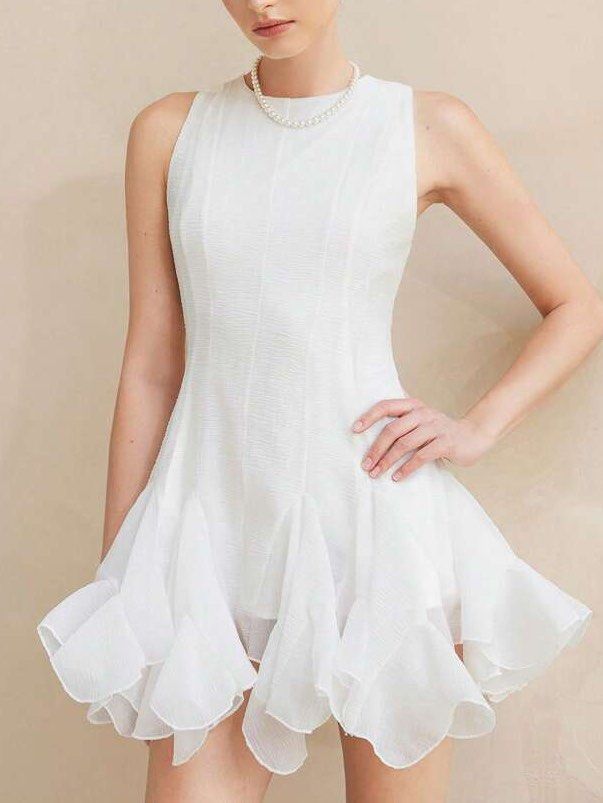 Shein Ruffled White Mini Dress (Category: Dresses) located in Binan City. Submitted by myprelovedhaul (Listing ID 1467948195, Image 1). Description: This item is a white crewneck short-sleeve mini dress featuring a distinctive dramatic layered ruffle hem. It is made from a lightweight, subtly textured semi-sheer fabric with panel detailing down the front torso that creates a structured, tailored look before flaring out into voluminous, cascading 