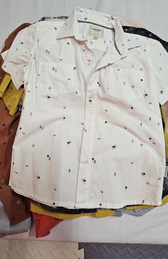 Short sleeve button down shirt bundle assorted colors (Category: Babies & Kids Fashion) located in Paranaque City. Submitted by mystuffmel (Listing ID 1467887285, Image 2). Description: 250 per pice if bundle 1200 only - Set of 7 casual short sleeve button-down shirts - Variety of designs: Black tie-dye, white with tree print, yellow with small icons, solid pink, and brown patterned - Features regular collars and convenient front pockets - Standa