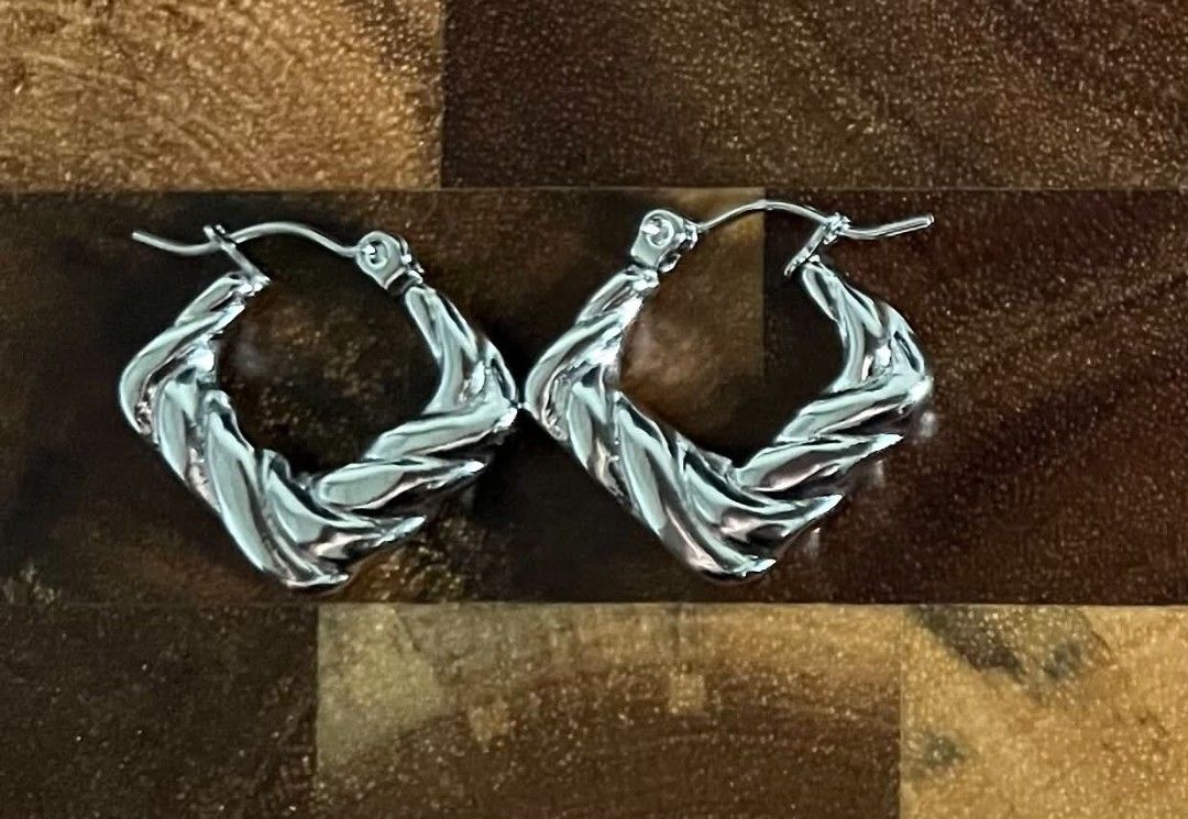 Silver Thick Twisted Geometric Hoop Earrings (Category: Earrings) located in Kananga. Submitted by aurylien.clo (Listing ID 1467941167, Image 1). Description: - Non-tarnish - Note 💌 proper care is recommended to maintain it's shine and preventing tarnishing - Bold chunky - Silver chunky hoop earrings with a stylish textured twist design - Modern square-shaped profile with a shiny metallic finish - Secure snap-bar closure for all-day comfort and 