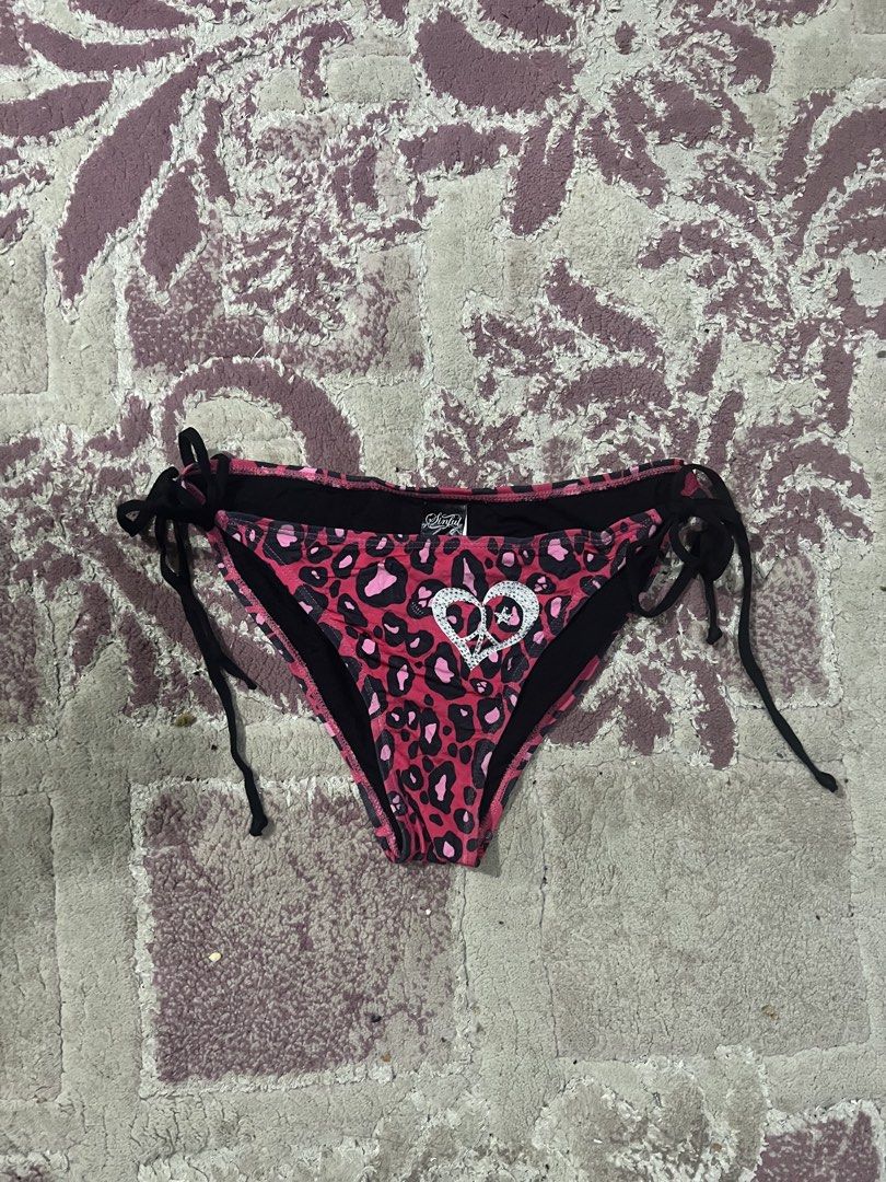 Sinful Pink Leopard Print Rhinestone Bikini Bottom Medium (Category: Bikinis & Swimsuits) located in Oroquieta. Submitted by zjstg (Listing ID 1467927842, Image 3). Description: - Style: Y2K pink and black leopard print bikini bottom - Size: Medium (tag attached) - Details: Sparkly rhinestone 'SINFUL' lettering on back waist, rhinestone peace heart graphic on front - Fit: Side tie strings with black loops - Condition: Brand new with tags, perfect