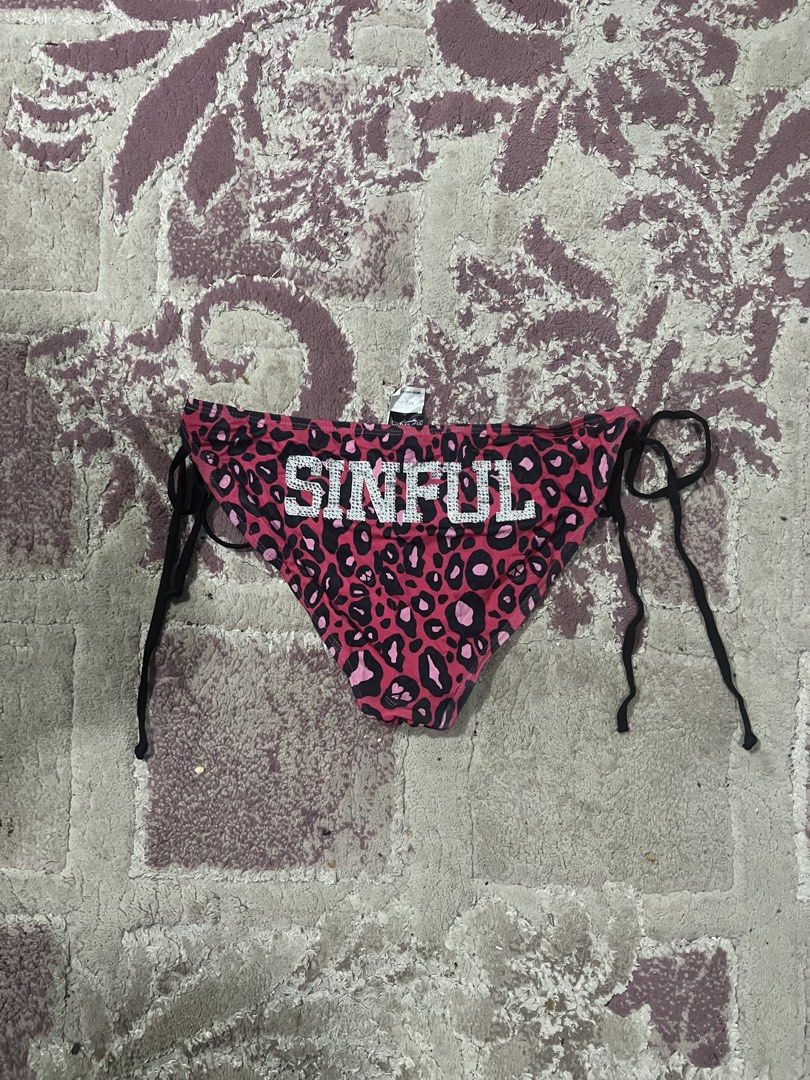 Sinful Pink Leopard Print Rhinestone Bikini Bottom Medium (Category: Bikinis & Swimsuits) located in Oroquieta. Submitted by zjstg (Listing ID 1467927842, Image 1). Description: - Style: Y2K pink and black leopard print bikini bottom - Size: Medium (tag attached) - Details: Sparkly rhinestone 'SINFUL' lettering on back waist, rhinestone peace heart graphic on front - Fit: Side tie strings with black loops - Condition: Brand new with tags, perfect