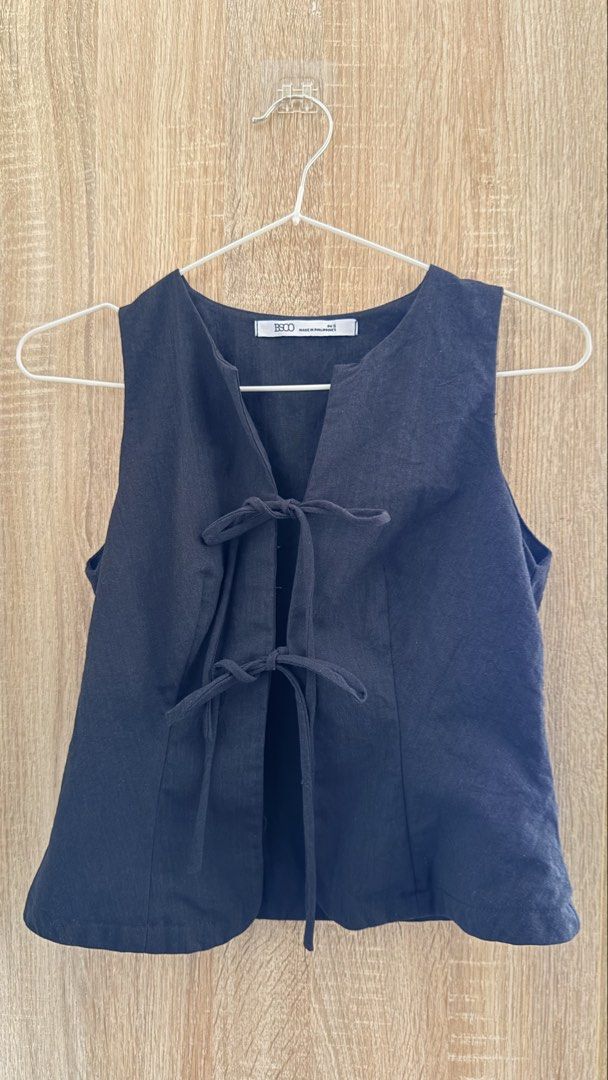 Sleeveless Tie-Front Top – BSCO (Category: Sleeveless) located in Santa Rosa. Submitted by stealbydiva (Listing ID 1467905869, Image 1). Description: - Brand: BSCO - Size: S - Color: Black - Design: V-neckline with front tie closure and two fabric bows - Fit: Fitted shape with clean back vertical dart seams - Fabric: Lightweight material - Versatility: Great for layering or wearing on its own.