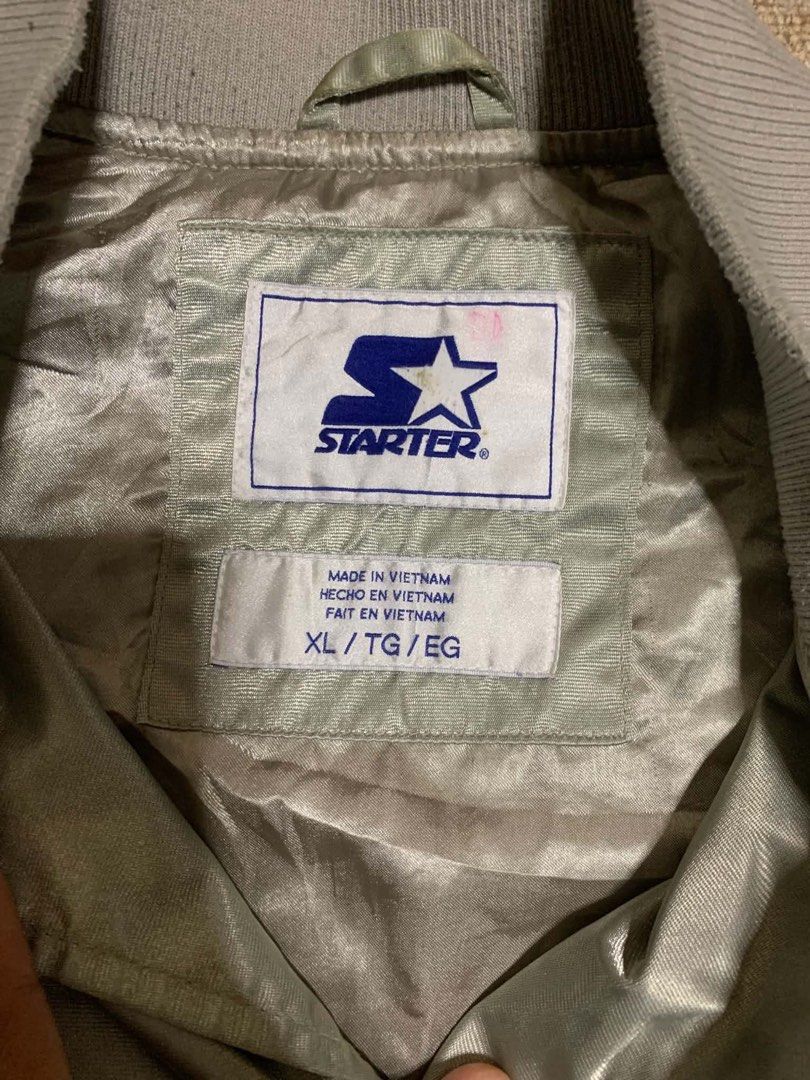 Starter Toronto Raptors Satin Bomber Jacket Grey XL (Category: Coats, Jackets and Outerwear) located in Tagum. Submitted by knilevinc69480 (Listing ID 1468006397, Image 2). Description: - Authentic Vintage Starter Toronto Raptors satin jacket - Color: Silver grey with black and white striped ribbed trim - Size: XL (Made in Vietnam) - Features: Snap button closure, embroidered team chest logo, and signature Star sleeve patch - Storage: Convenient 