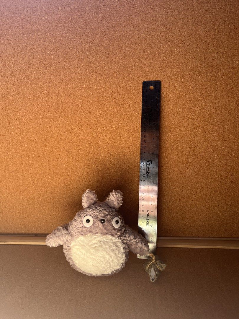 Studio Ghibli Totoro Plush Toy Stuffed Doll (Category: Plushies & Soft Toys) located in Baguio. Submitted by gaara1234 (Listing ID 1467858476, Image 1). Description: - Adorable Grey Totoro plushie with white fluffy belly, pointy ears, and round black eyes - Features a cute small fabric bundle attached to one hand - Compact size: roughly 11 cm tall - Made of soft, fuzzy material - Clean exterior with no obvious damage or stains.