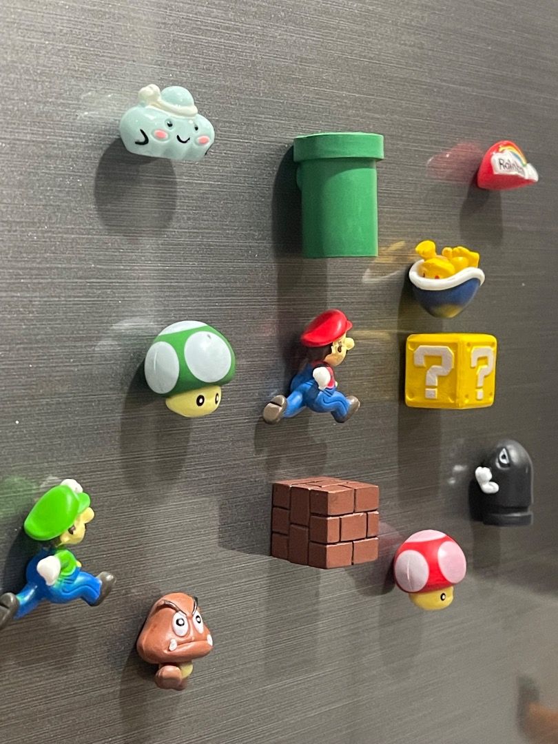 Super Mario refrigerator magnets characters and items set (Category: Character Goods) located in Subic. Submitted by anything_lovely_under_the_sun (Listing ID 1467938346, Image 2). Description: - Super Mario fridge magnet set (11 pieces included) - Characters & items: Mario, Luigi, Goomba, Green/Pink Mushrooms, Bullet Bill, Green Pipe, Question Block, Brick Block, Rainbow Cloud, and Blue Shell - Size: Around 2 cm tall each - Features: Magnetic ba
