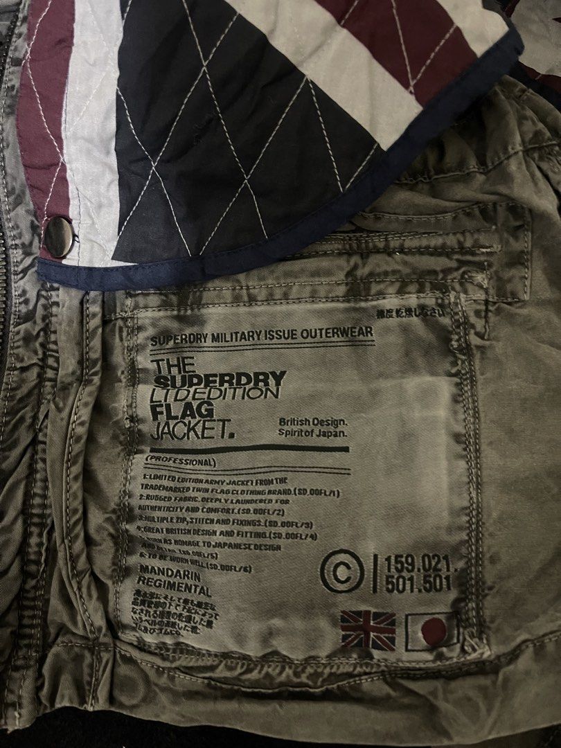 Superdry Limited Edition Flag Jacket Military Issue (Category: Coats, Jackets and Outerwear) located in La Trinidad. Submitted by potatothriftlip (Listing ID 1468057806, Image 2). Description: - Brand: Superdry - Style: Military Issue Limited Edition Flag Jacket - Color/Wash: Grey - Details: Mandarin regimental collar with snap buttons, metal hardware - Pockets: Multiple utility pockets for functionality - Waist: Adjustable drawstring with black 