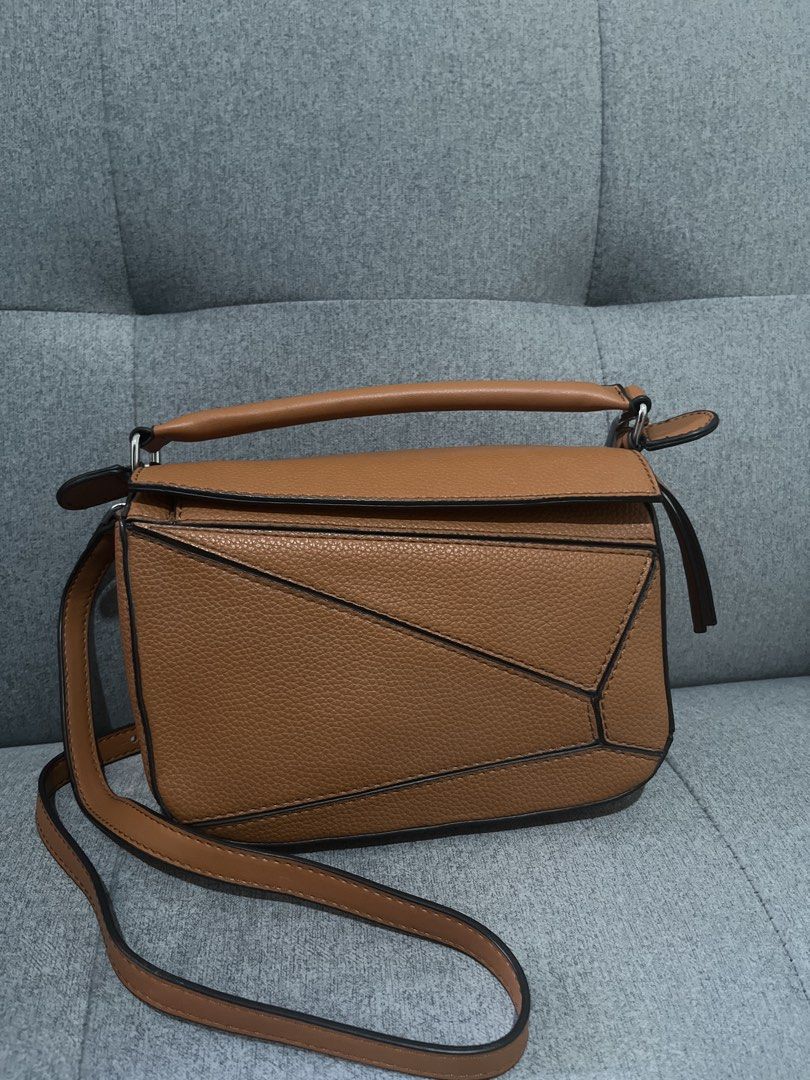 Tan Puzzle Bag Crossbody (Category: Cross-body Bags) located in Las Pinas. Submitted by erenrosc (Listing ID 1467915255, Image 1). Description: - Material & Finish: Premium tan leather with a stylish textured grain finish - Design: Distinct geometric panel design highlighted with chic black edge painting - Versatility: Comes with a sturdy top handle and an adjustable shoulder strap with sleek silver-tone hardware - Closure: Secure zip closure tuc