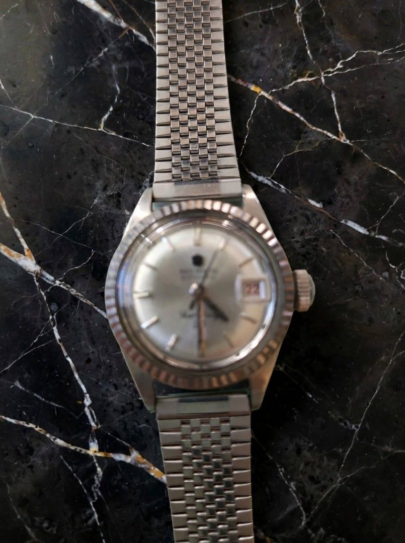 Technos Vintage Watch (Category: Women's Watches) located in Caloocan City. Submitted by chonadura91470 (Listing ID 1467916479, Image 2). Description: - Brand: technos vintage watch produce in the 60's and 70's - Movement: Automatic (winds smoothly) - Dial: Silver sunburst with fluted bezel - Date: 3 o'clock position with unique red numbers - Material: Stainless steel case with vintage mesh-style metal bracelet - Details: Sonnige stamped case bac