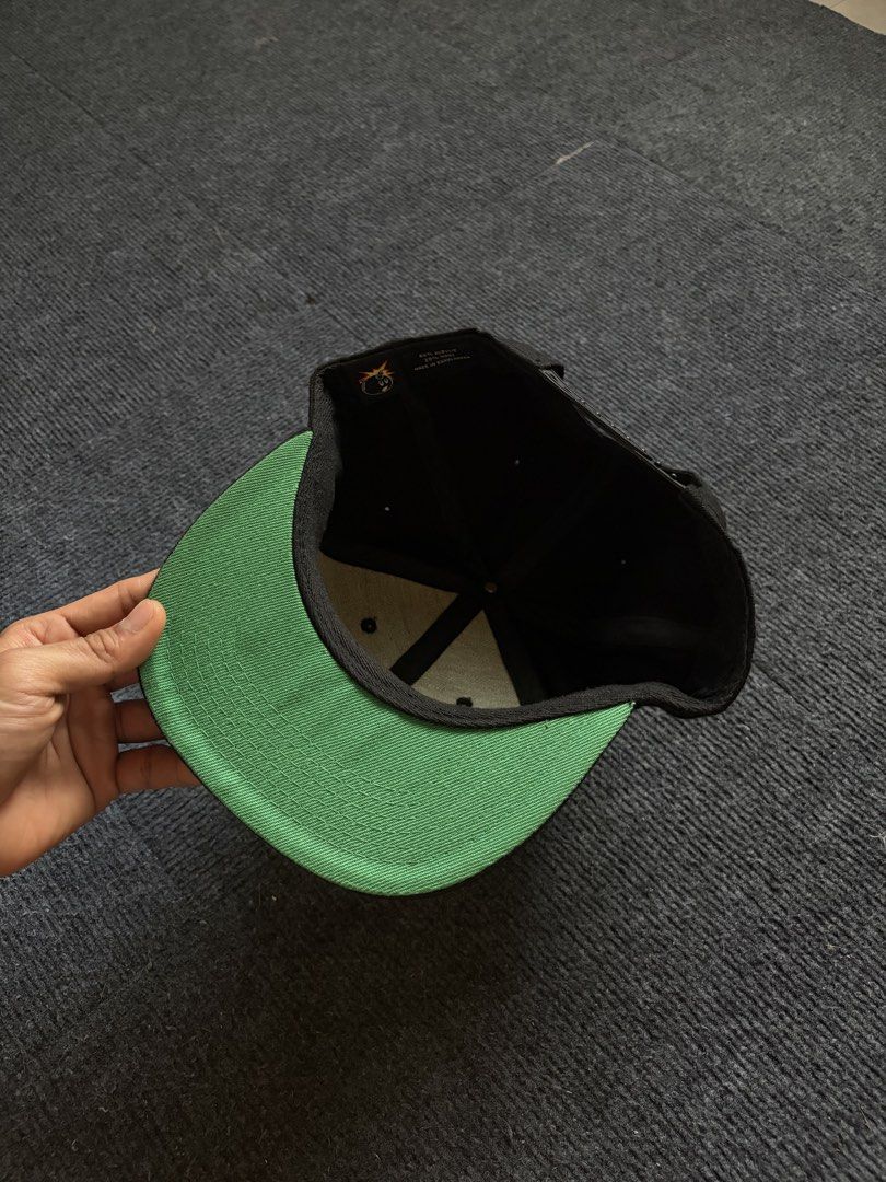 The Hundreds Snapback Hat Black Green Undervisor (Category: Caps & Hats) located in Manila. Submitted by toys_hats005 (Listing ID 1467955616, Image 3). Description: - Brand: The Hundreds - Color: Black with burgundy and yellow embroidered logo patch - Under brim: Classic green undervisor - Fit: Adjustable plastic snapback closure - Material: 80% acrylic, 20% wool - Condition: Clean interior lining with original brand tags intact.